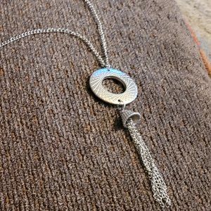 Long Silver toned necklace with circle and bell decoration